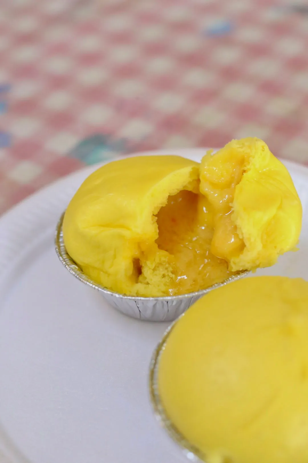 A yellow golden sand pau broken open to show salted egg custard