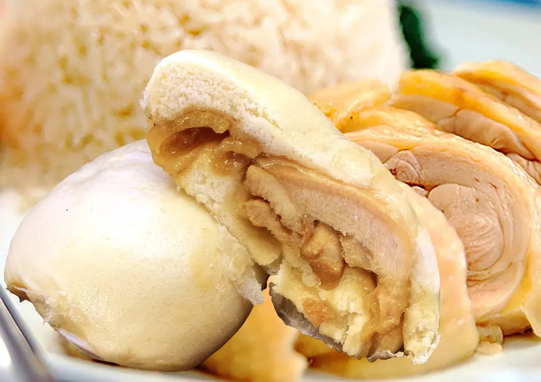 Chicken rice pau cut open to show a piece of chicken thigh