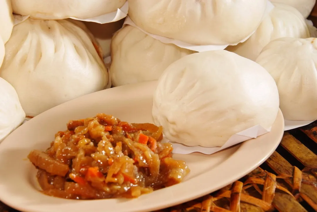 A plate of vegetable pau filling in front of steamed pau