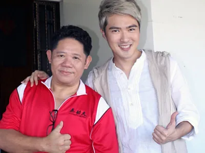 Two men giving a thumbs up, one in a red Kung Fu JB Pau polo and one in a white shirt